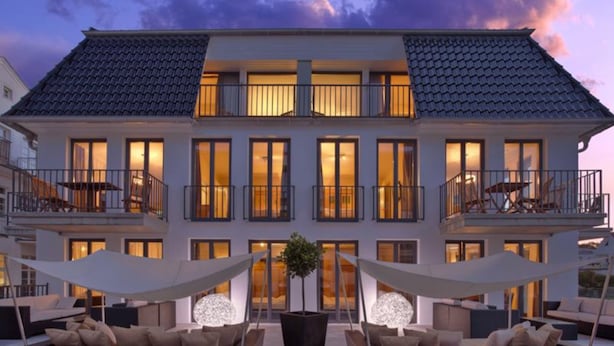 A two-story building with a balcony on each floor, large windows, and outdoor seating areas. - Suite Hotel Binz Familienhotel Rügen (Binz)