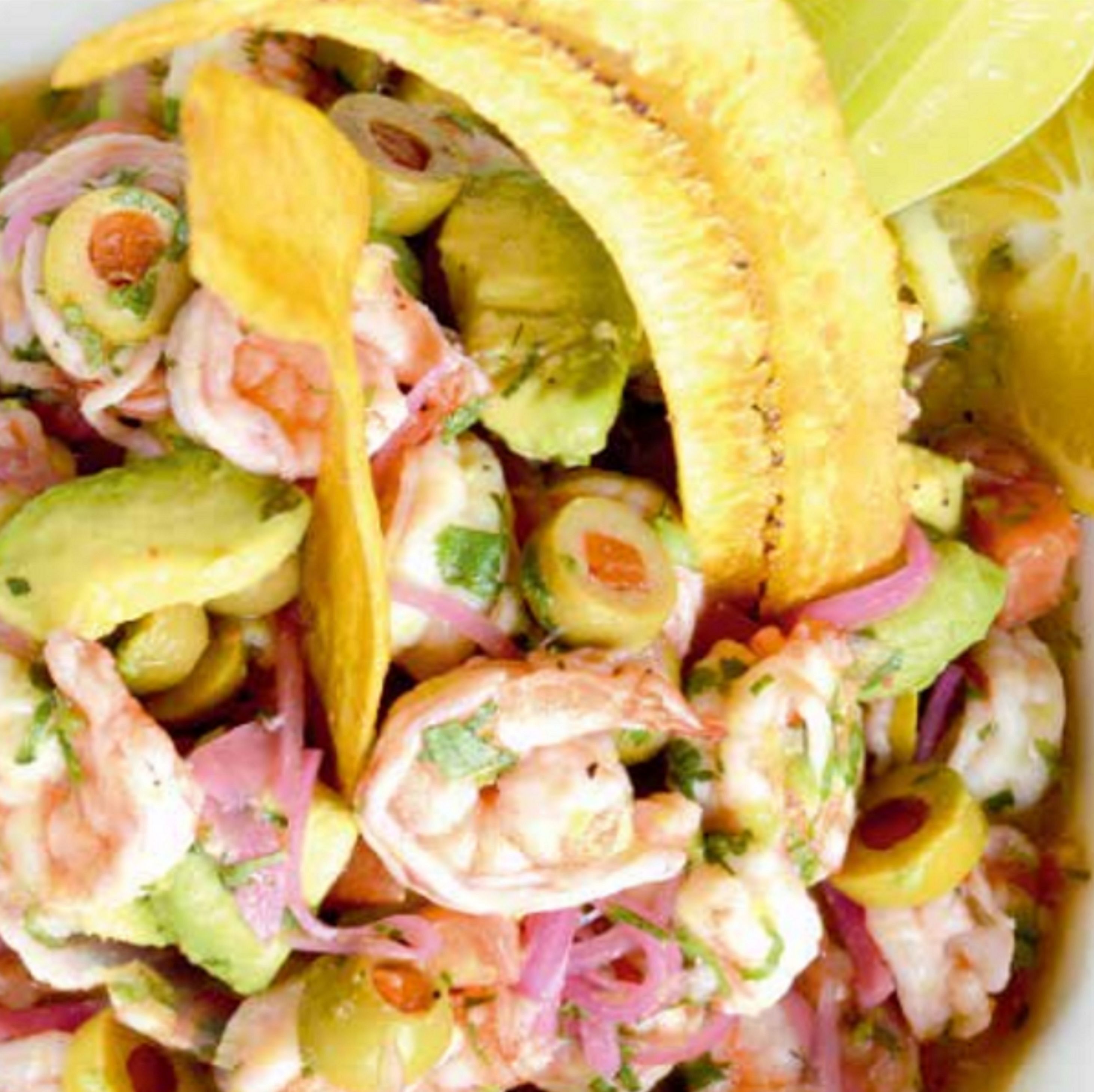Gros plan d’une salade de fruits de mer à l’avocat, aux crevettes et à l’oignon rouge.