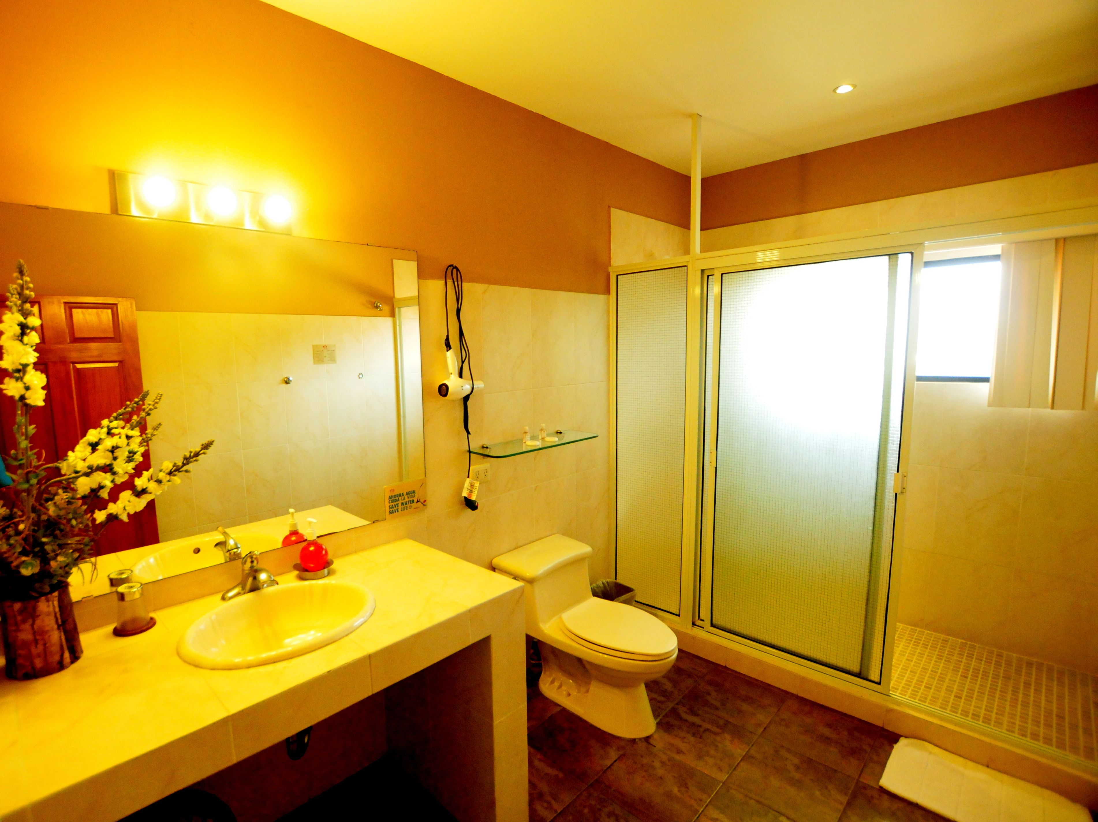 A modern bathroom with a sink, toilet, and glass shower enclosure.