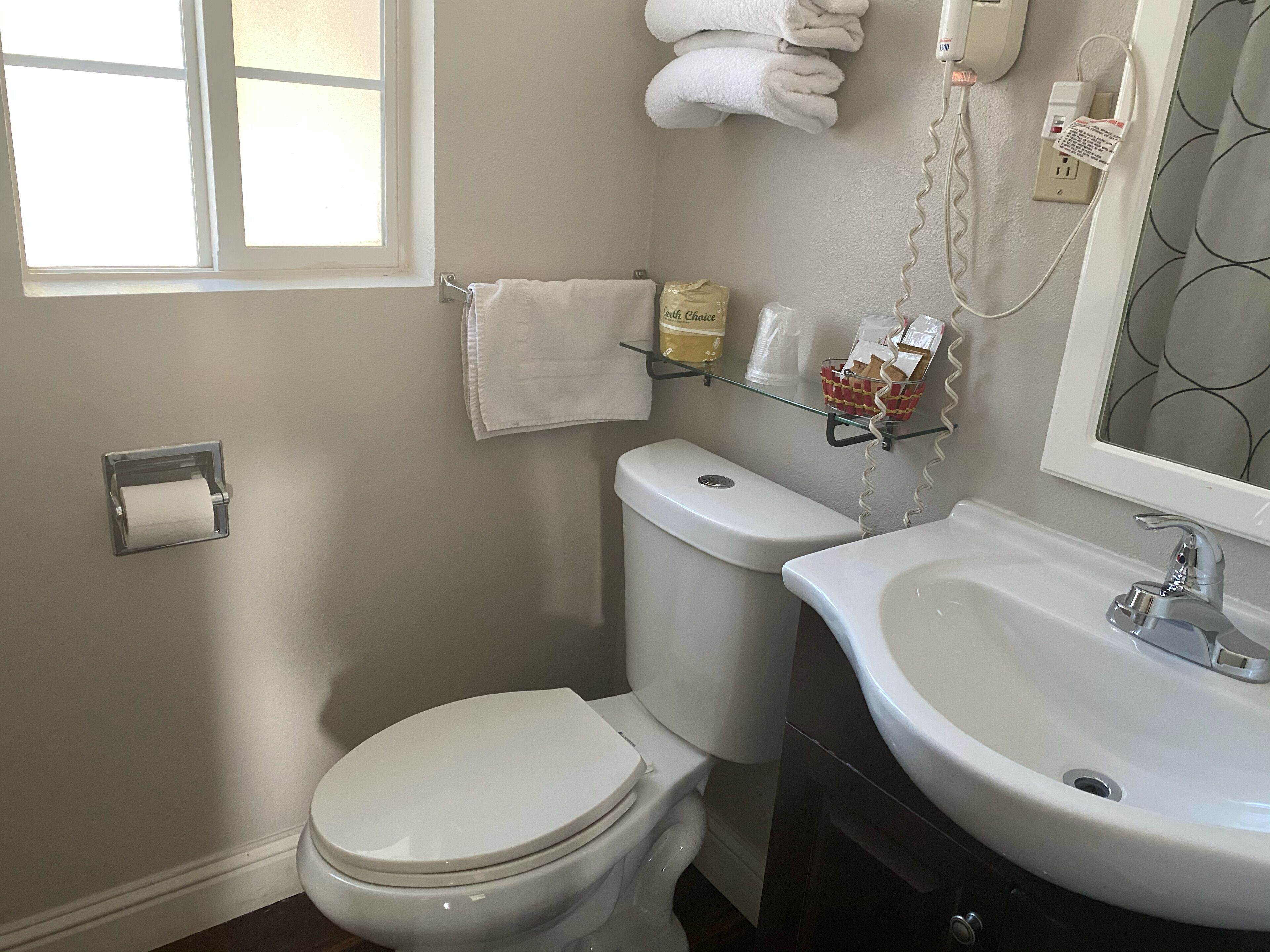 A bathroom with a toilet, sink, and a towel rack.