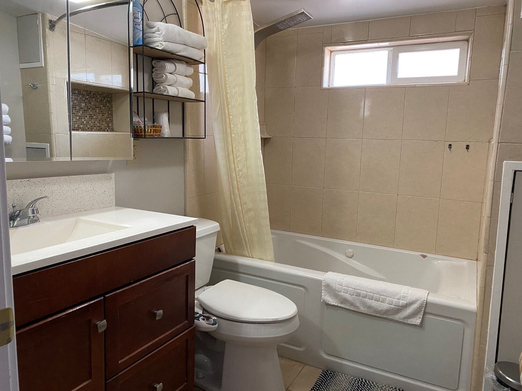 Une salle de bain avec un lavabo blanc, des toilettes, une baignoire et un espace douche.