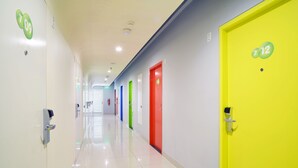 A hallway with doors numbered 7, 9, and 12, and a fire extinguisher on the wall.