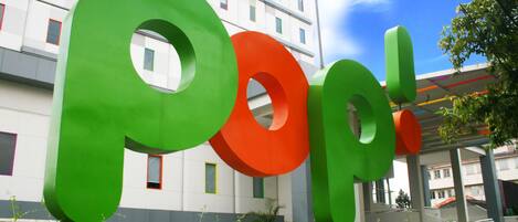 A large outdoor sign with the letters "Pop!" in green and orange.