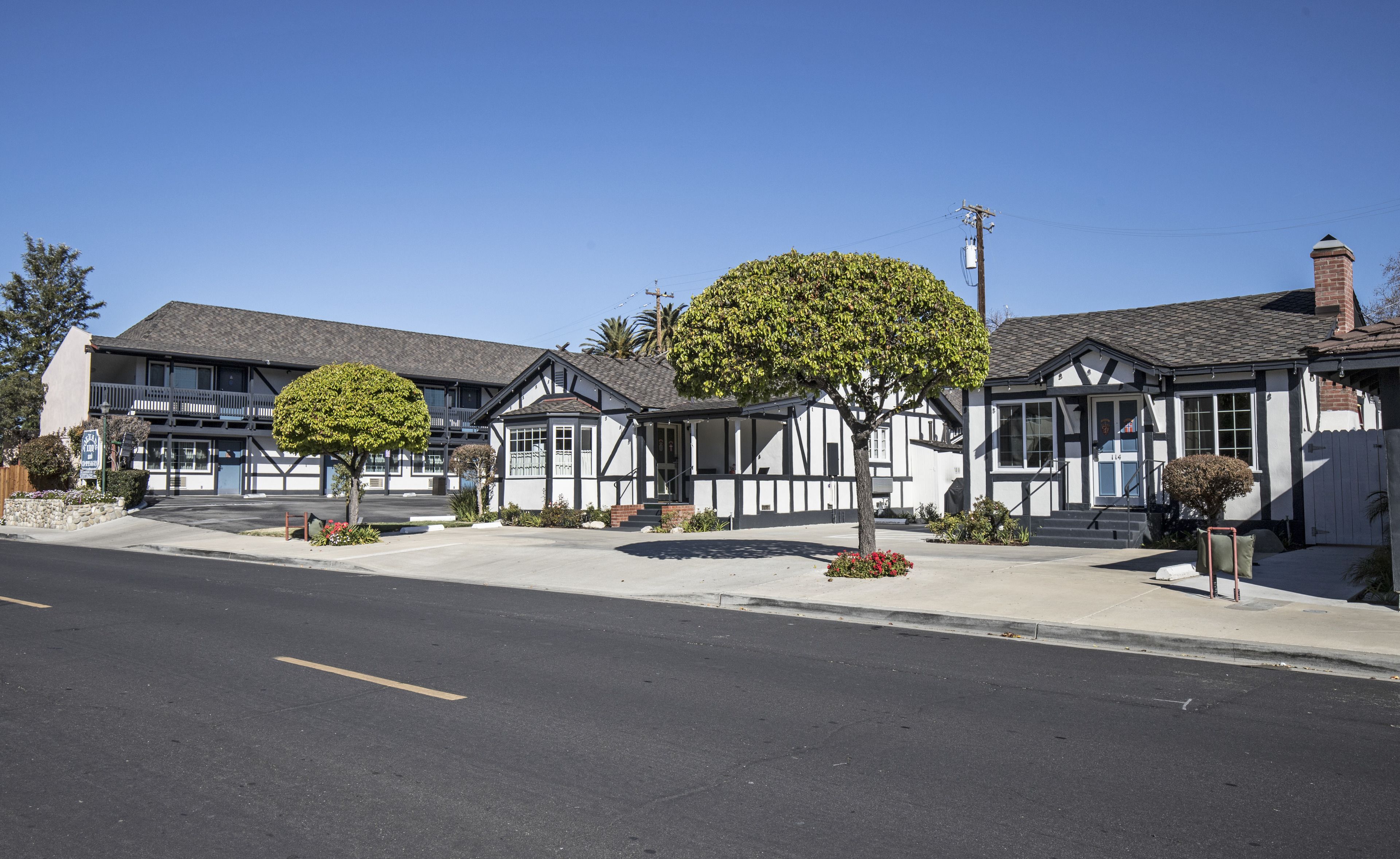 A row of two-story buildings with a central courtyard, featuring a mix of residential and commercial spaces.