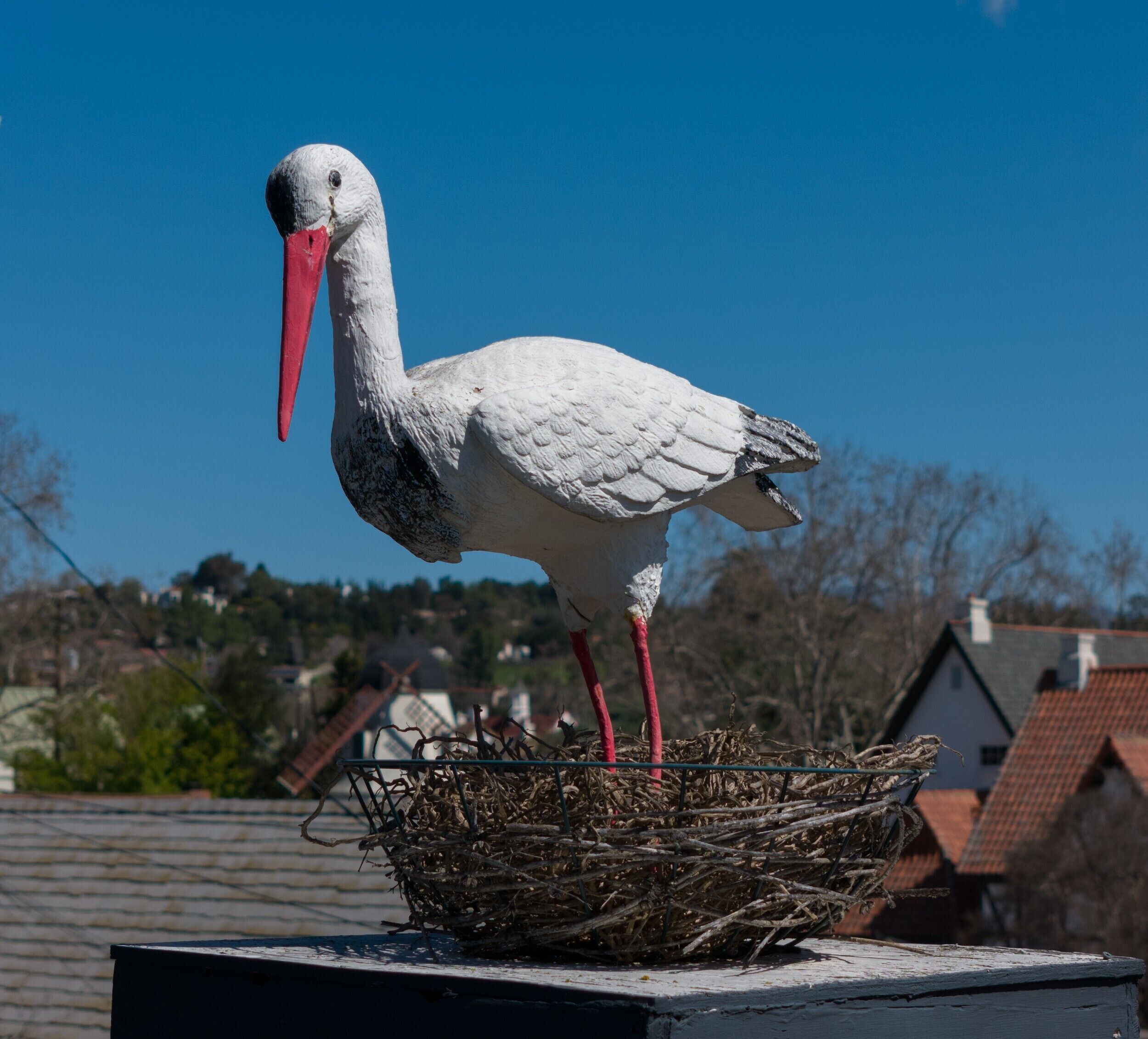 A stork standing on a nest atop a building.