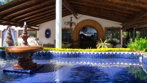 A building with a tiled pool, a fountain, and a covered patio area. - Hotel El Rebozo (Valle de Bravo)
