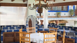 A patio with blue and white tiles, wooden furniture, and a statue. - Hotel El Rebozo (Valle de Bravo)