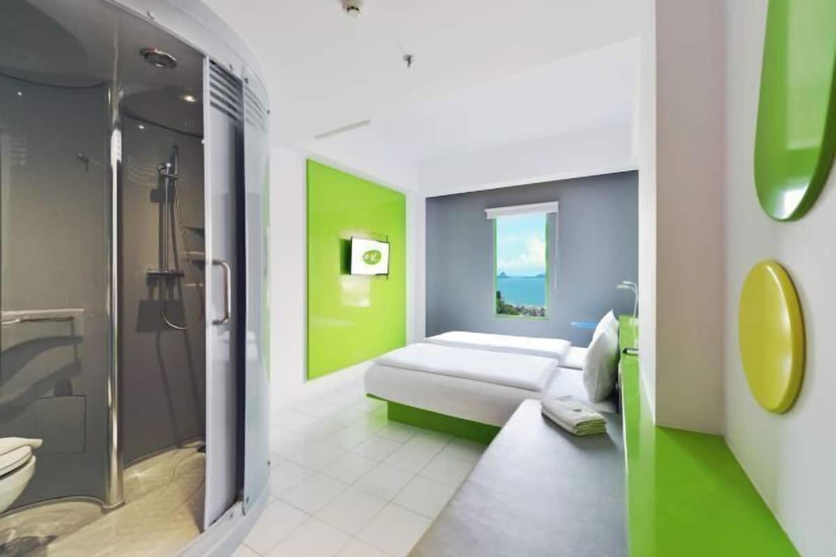Een moderne badkamer met douche, toilet en een groene accentmuur.