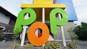 Une enseigne d’hôtel avec de grandes lettres colorées qui épellent le mot « POP ! » et le mot « HÔTEL » en dessous.