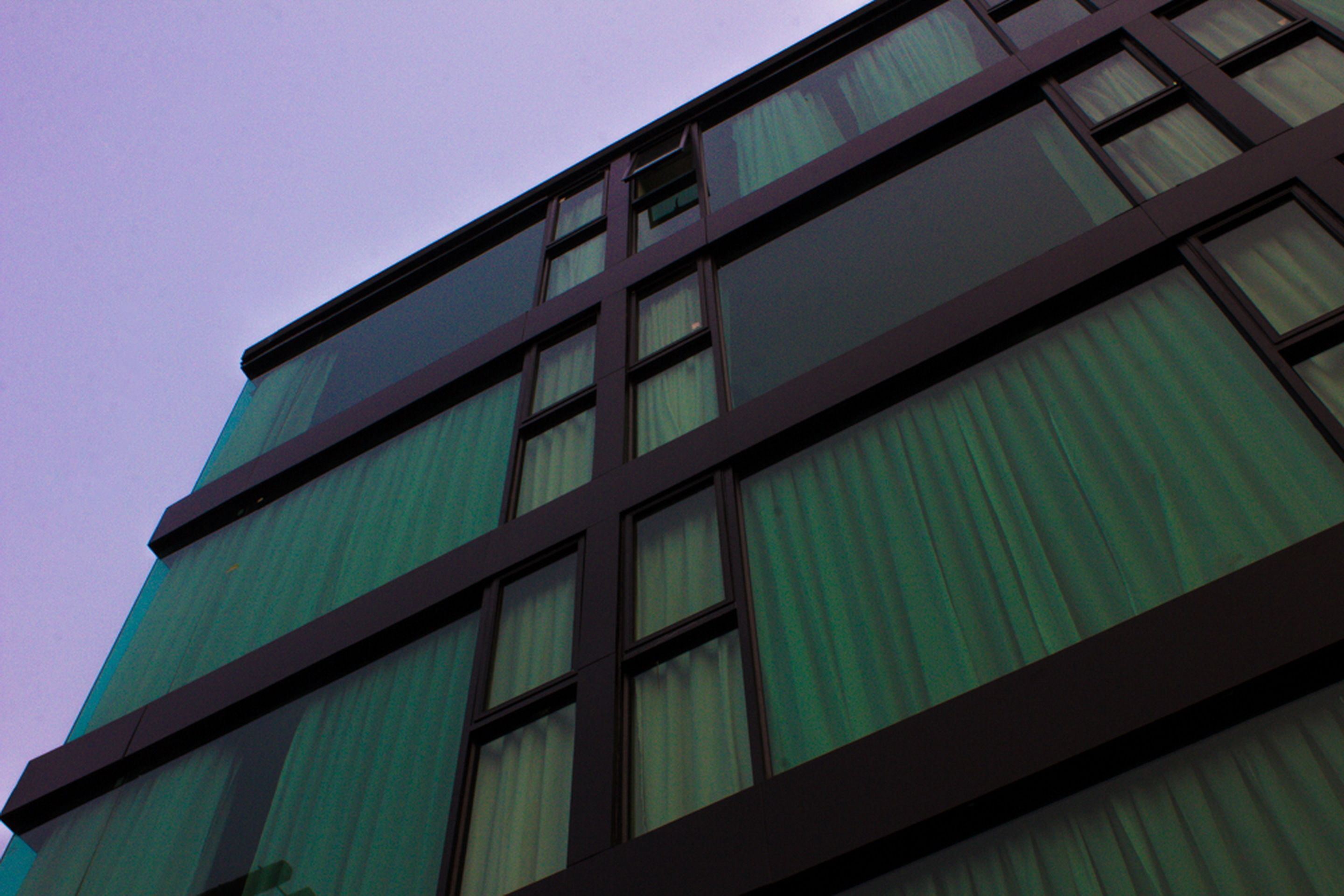 A multi-story building with a modern architectural design, featuring large windows and a structured facade.
