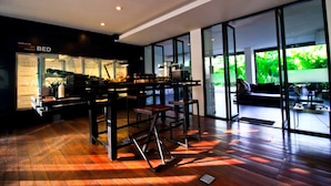 Un intérieur moderne avec un bar, de grandes fenêtres et un plancher en bois.