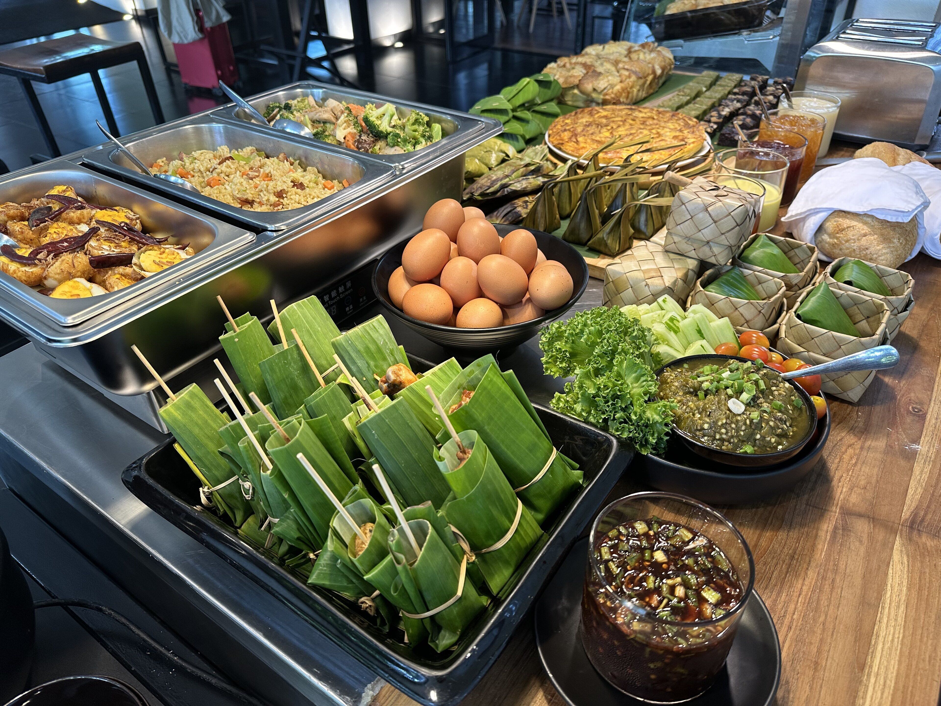 Ein Buffet mit verschiedenen Speisen, darunter Reisgerichte, Eier und einer Auswahl an Beilagen.