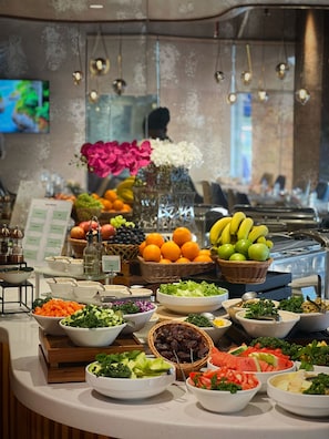 A buffet with various food items including fruits, vegetables, and salads. - Baity Hotel Apartments (Dubai)