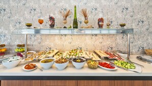 Un bufé con diferentes platillos y un centro de mesa decorativo.