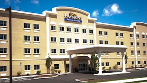 A large, multi-story hotel with a prominent entrance and a clear blue sky in the background. - Baymont by Wyndham Erie (Erie)