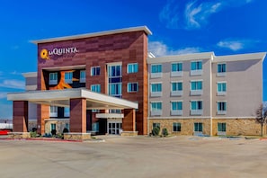 Un hotel La Quinta con un diseño moderno, que cuenta con una entrada destacada y varios balcones.