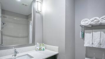 Une salle de bain moderne avec un lavabo blanc, un miroir et un porte-serviettes.