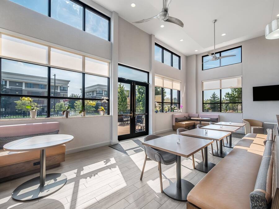 A modern interior with large windows, a seating area, and a flat-screen TV.