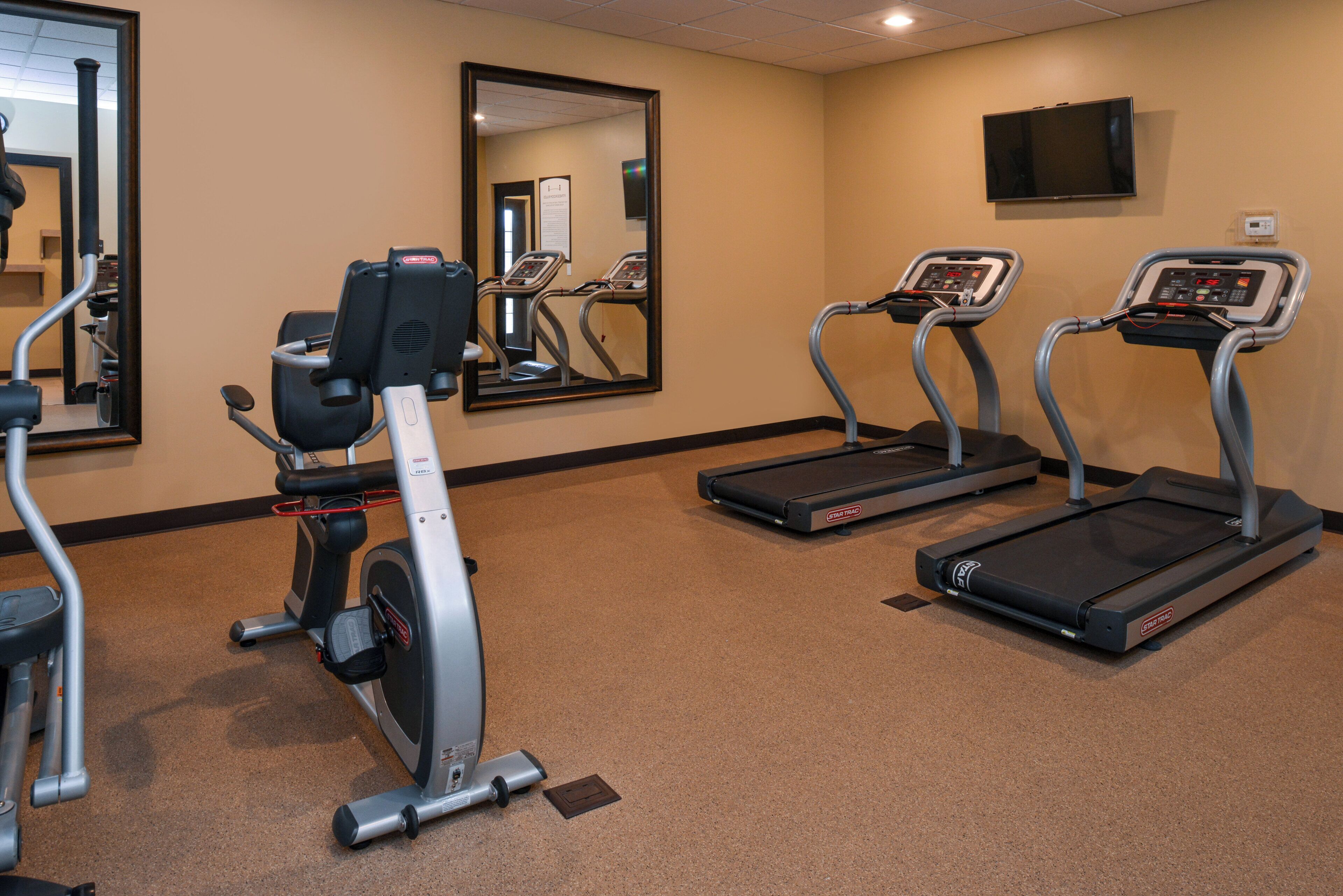 A fitness room with treadmills, an elliptical, and a stationary bike.