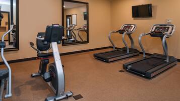 A fitness room with treadmills, an elliptical, and a stationary bike.
