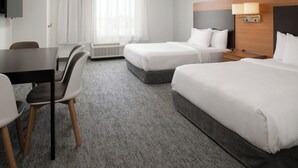 A hotel room with two beds, a desk, chairs, and a TV. - TownePlace Suites by Marriott Lancaster, CA (Lancaster)