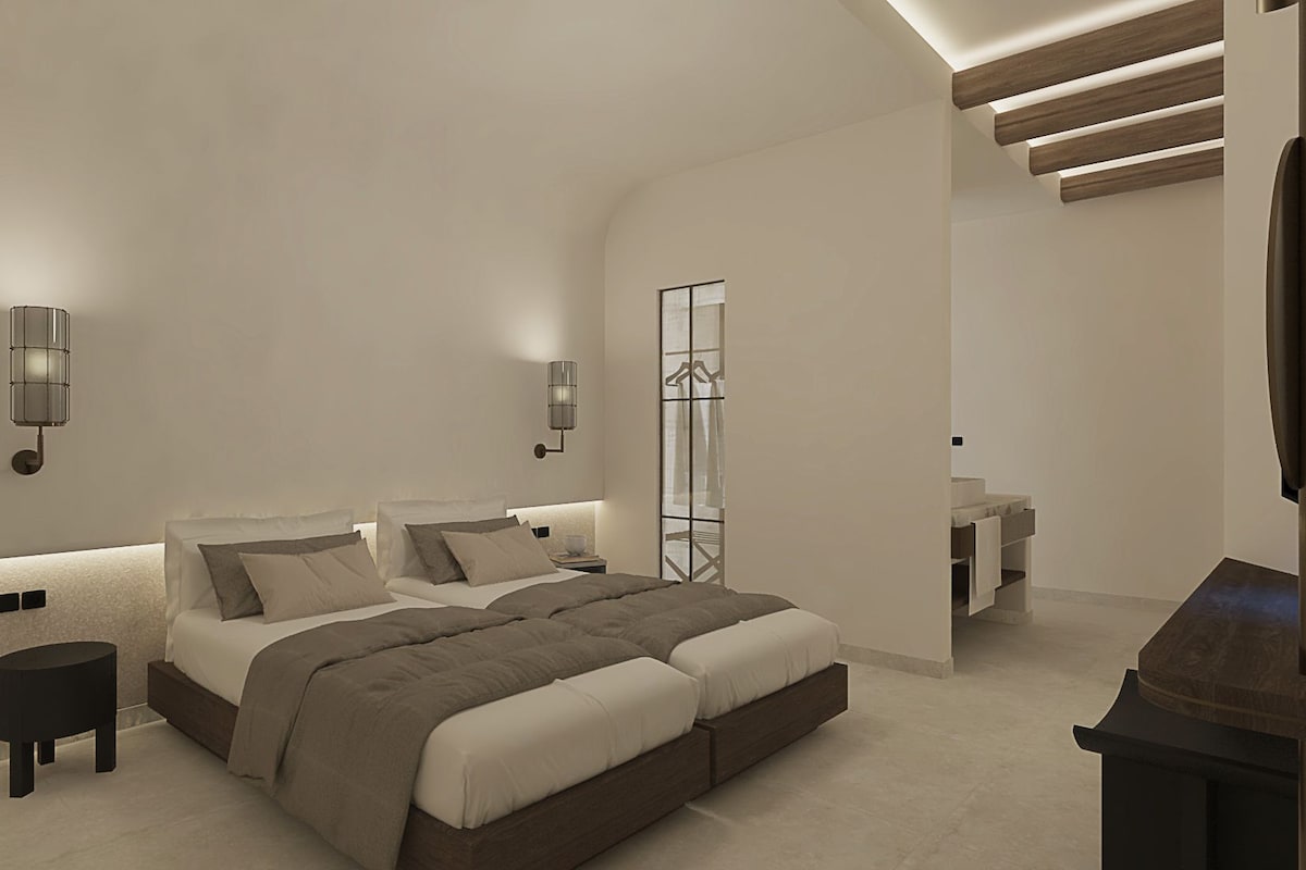 A modern bedroom with a large bed, bedside tables, a TV, and a walk-in closet.