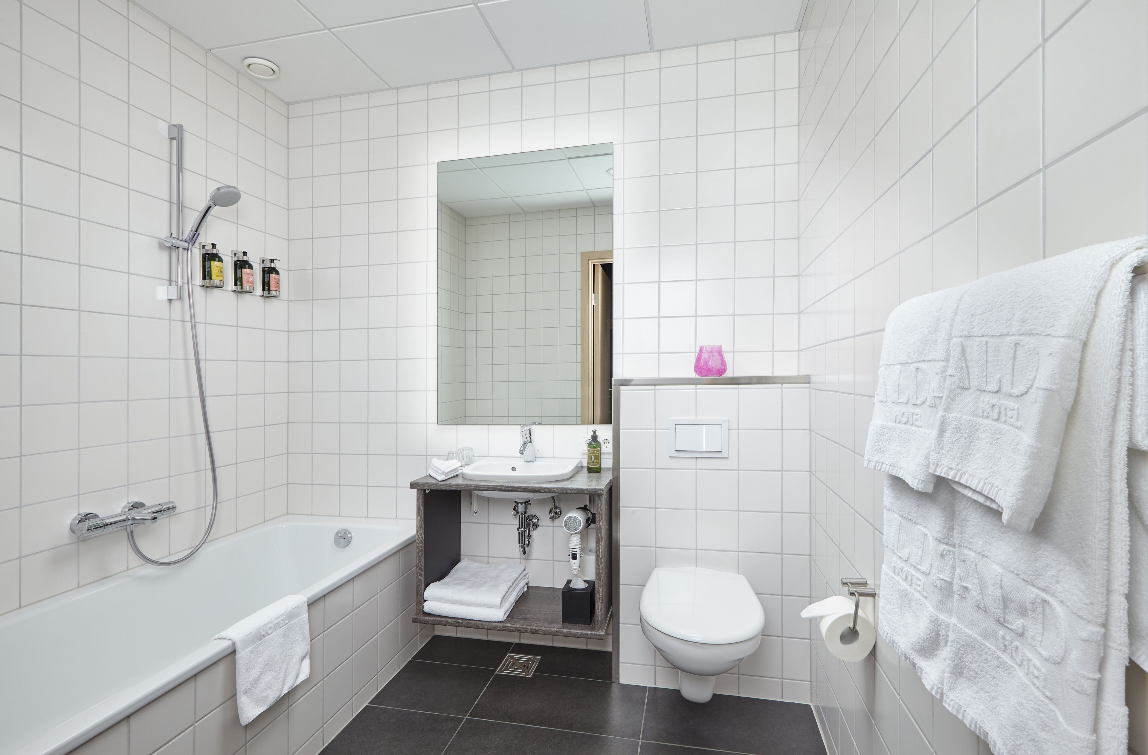 A modern bathroom with a bathtub, toilet, and sink.