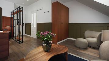 A modern living room with a wooden coffee table, a sofa, and a wooden cabinet. There is a vase with flowers on the table.