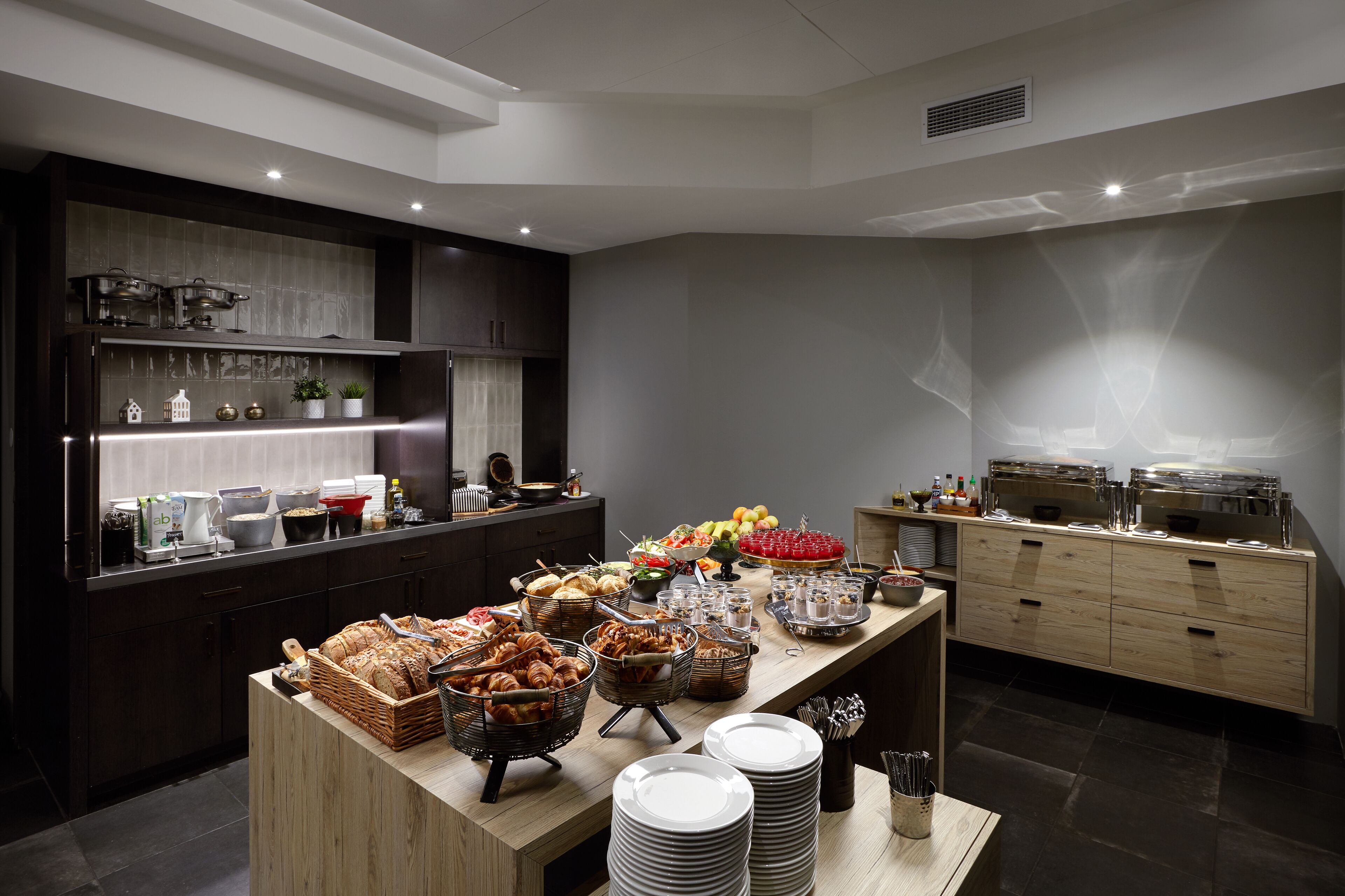 Un buffet proposant une variété de plats et d’ustensiles de service.