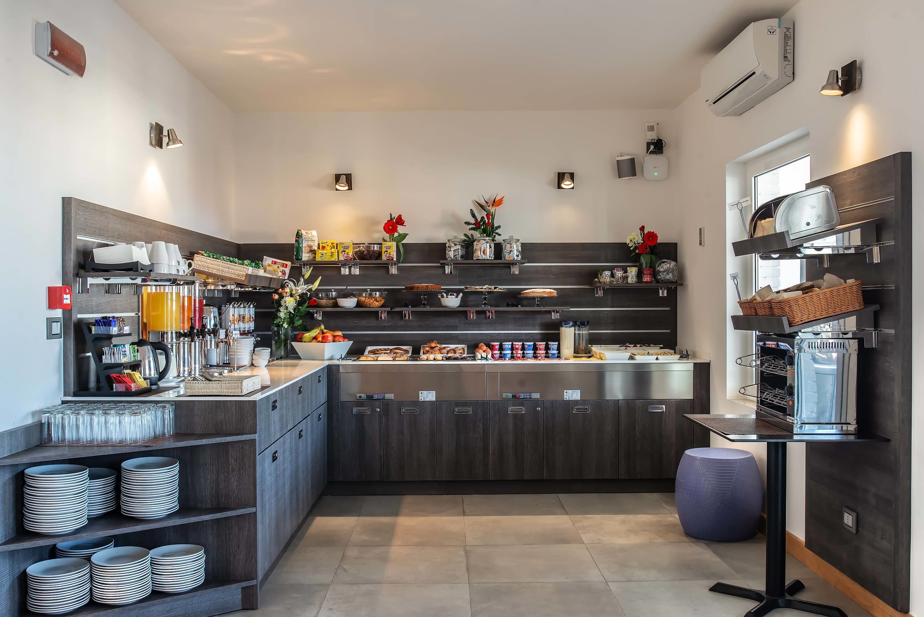 A modern kitchen with a central island, built-in appliances, and various food items and utensils.