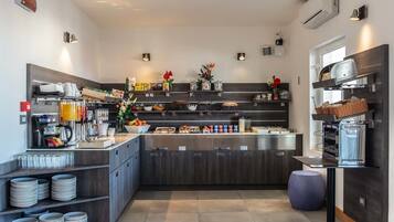 A modern kitchen with a central island, built-in appliances, and various food items and utensils.