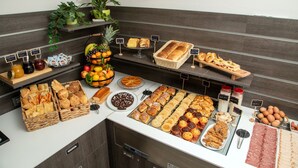 A buffet with various food items including breads, pastries, fruits, and condiments. - Fragrance Hotel St. Peter (Rome)