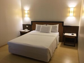A hotel room with a large bed, two bedside tables, a nightstand, and wall-mounted lamps. - Master Express Lima e Silva (Porto Alegre)