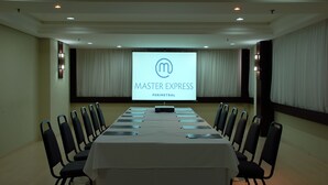 A conference room with a long table, chairs, and a large screen displaying 'Master Express Perimetral'. - Master Express Lima e Silva (Porto Alegre)