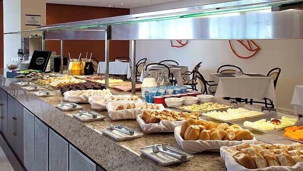 A buffet setup with various food items and beverages. - Master Grande Hotel (Porto Alegre)