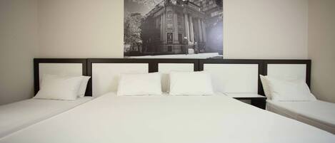 A hotel room with a large bed, two bedside tables, and a framed picture on the wall.