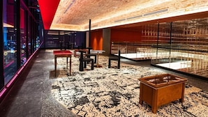 Een modern interieur met een houten plafond, glazen wanden en een kamerbreed tapijt met dessin.