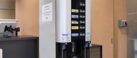 Un dispensador de bebidas automático con varias opciones, una pantalla digital y un letrero que indica que es solo para huéspedes.
