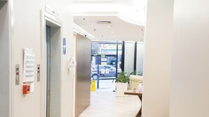 A clean, well-lit hallway with a trash bin, a reception desk, and a sign indicating a restaurant. - Master Express Alberto Bins (Porto Alegre)