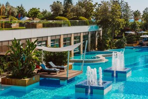 Una piscina cubierta, una piscina al aire libre, sombrillas, tumbonas