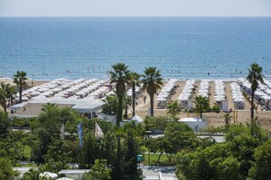 Una playa cerca, sillas reclinables de playa, sombrillas, ski acuático