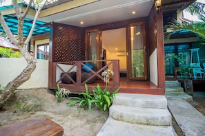 A wooden house with a porch, steps leading to a door, and a small garden area with plants. - B52 Beach Resort (Ko Pha-ngan)
