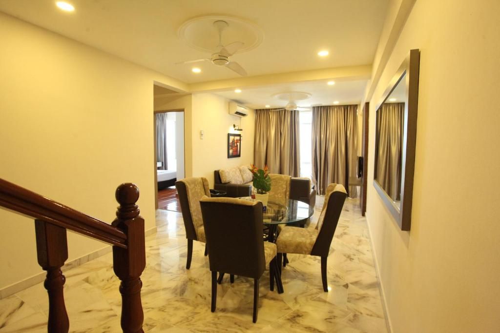 A hotel dining area with a round table, chairs, and a ceiling fan.