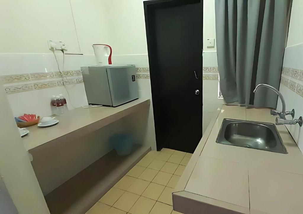 A compact kitchen with a sink, a coffee maker, and a refrigerator.