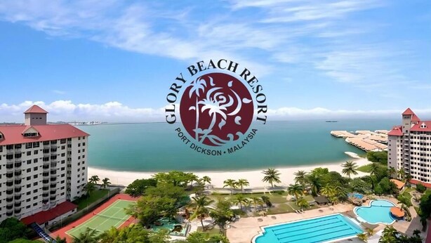 A resort with a view of the beach, a logo, and a pool.