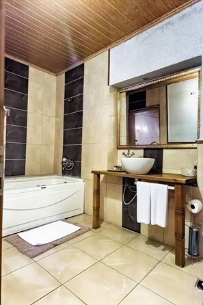 A modern bathroom with a freestanding bathtub, a vanity with a large mirror, and a toilet. - Saklı Konak Cappadocia (Nevsehir)