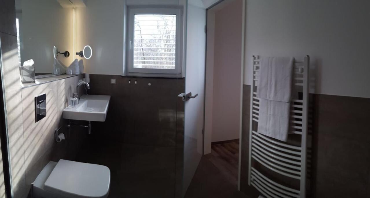 A compact bathroom with a toilet, sink, and mirror.