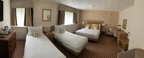 A hotel room with two beds, a desk, a chair, and a small table. - Haley's Hotel (Leeds)