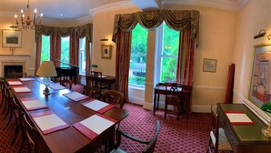 A formal dining room with a long table set for a meal, a piano, and a fireplace. - Haley's Hotel (Leeds)