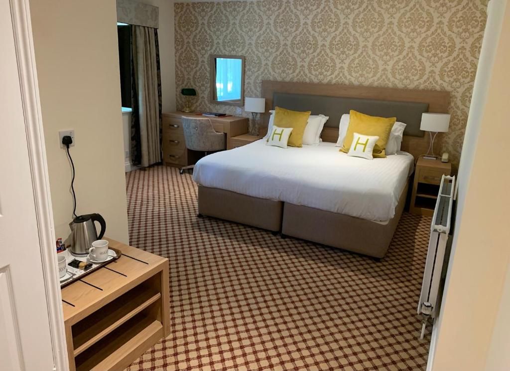 A hotel room with a large bed, bedside tables, a desk, and a view of the outside.